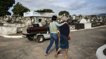 Relatives accompany the coffin that contains the remains of 89-year-old Irodina Pinto Ribeiro, who died from COVID-19 related complications, at the Inhauma cemetery in Rio de Janeiro, Brazil, Friday, June 18