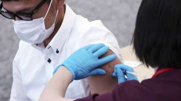In this Monday, June 21, 2021, file photo, an employee of the beverage maker Suntory takes a Moderna COVID-19 vaccine shot at their office building as the company began its workplace vaccination in Tokyo.