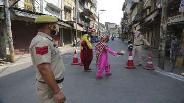 Policemen direct pedestrians towards a COVID-19 testing booth at a market during a lockdown to curb the spread of coronavirus in Jammu.