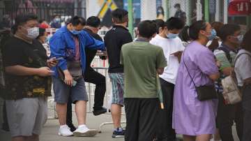 Residents wearing face masks to help curb the spread of the coronavirus line up to receive their vaccine at a vaccination point at the Central Business District in Beijing.