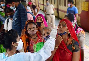 A medic collects nasal sample from a passenger at Dadar station to curb COVID-19 spread in Mumbai