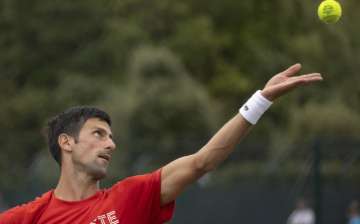 Serbia'a Novak Djokovic serves, during his practice match, prior to the Wimbledon Tennis Championships in London, Saturday June 26