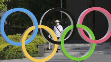 A man walks past the Olympic rings in Tokyo, Monday, June 7, 2021