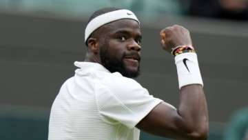 Frances Tiafoe of the US celebrates after breaking the serve of Stefanos Tsitsipas of Greece during the men's singles match on day one of the Wimbledon Tennis Championships in London, Monday June 28