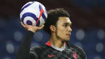 Liverpool's Trent Alexander-Arnold holds up the ball during the English Premier League soccer match between Burnley and Liverpool at Turf Moor in Burnley, England, Wednesday May 19
