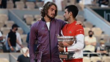 Serbia's Novak Djokovic, right, and Stefanos Tsitsipas of Greece hug while holding their trophies after their final match of the French Open tennis tournament at the Roland Garros stadium Sunday, June 13