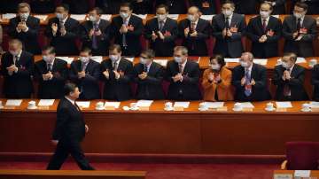 Chinese President Xi Jinping, foreground center, and high ranking officials stand for the national anthem during the opening session of Chinese Peoples Political Consultative Conference.