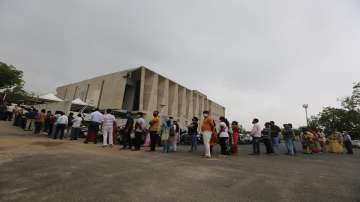 People stand in a queue to get vaccinated for COVID-19 at a vaccination centre in Ahmedabad.