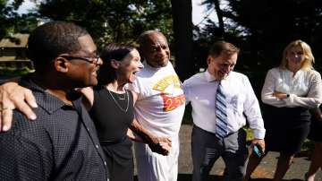 Bill Cosby, center, listens to members of his team speaks with members of the media outside Cosby's home in Elkins Park, Pa., Wednesday, June 30, 2021, after Pennsylvania's highest court overturned his sex assault conviction.