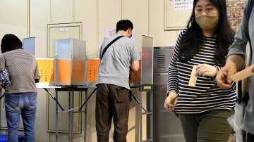 Voters cast their ballots at a polling station in Tokyo Sunday, July 4