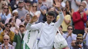 Serbia's Novak Djokovic waves to the crowd as he leaves the court after defeating Chile's Cristian Garin during the men's singles fourth round match on day seven of the Wimbledon Tennis Championships in London, Monday, July 5