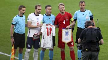 England's Harry Kane, 2nd left, hands to Denmark's Simon Kjaer an English shirt with the name of Denmark's Christian Eriksen before the Euro 2020 soccer championship semifinal match between England and Denmark at Wembley stadium in London, Wednesday, July 7