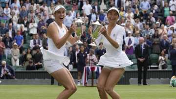 Belgium's Elise Mertens, left, and Taiwan's Su-Wei Hsieh pose for the media with their winners trophies after defeating Russia's Elena Vesnina, and Russia's Veronica Kudermetova in the women's doubles final on day twelve of the Wimbledon Tennis Championships in London, Saturday, July 10