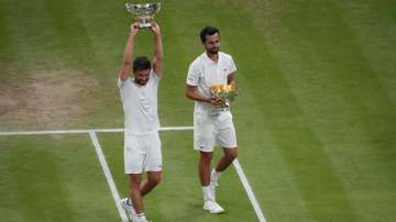 Croatia's Nikola Mektic, left, and Mate Pavic celebrate with their trophies after defeating Spain's Marcel Granollers and Argentina's Horacio Zeballos during the men's doubles final match on day twelve of the Wimbledon Tennis Championships in London, Saturday, July 10