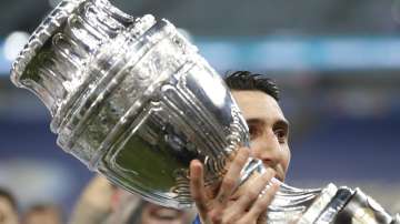 Argentina's Angel Di Maria holds the trophy as he celebrates with teammates after beating 1-0 Brazil in the Copa America final soccer match at the Maracana stadium in Rio de Janeiro, Brazil, Saturday, July 10