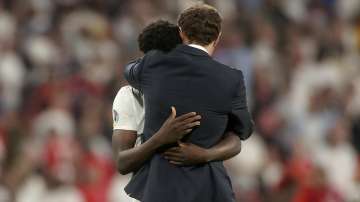 England's manager Gareth Southgate embraces Bukayo Saka after he failed to score a penalty during a penalty shootout after extra time during of the Euro 2020 soccer championship final match between England and Italy at Wembley stadium in London, Sunday, July 11