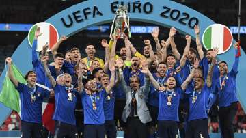 Italy's team celebrates with the trophy on the podium after winning the Euro 2020 soccer championship final between England and Italy at Wembley stadium in London, Sunday, July 11