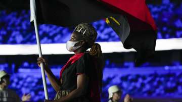 Natalia Santos of Angola, carry her country's flag during the opening ceremony in the Olympic Stadium at the 2020 Summer Olympics, Friday, July 23