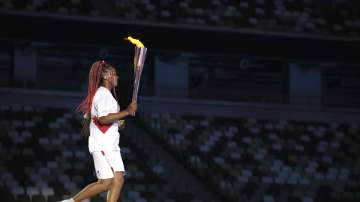 Naomi Osaka carries the Olympic Torch during the opening ceremony in the Olympic Stadium at the 2020 Summer Olympics, Friday, July 23, 2021, in Tokyo, Japan