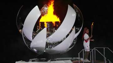 Naomi Osaka stands beside the Olympic flame after lighting it during the opening ceremony 