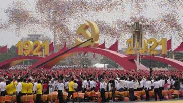Balloons float over attendees waving Chinese flags during a ceremony at Tiananmen Square to mark the 100th anniversary of the founding of the ruling Chinese Communist Party in Beijing Thursday, July 1