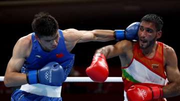 Ashish Kumar (R) of India exchanges punches with Erbieke Tuoheta of China during the Men's Middle (69-75kg) on day three of the Tokyo 2020 Olympic Games at Kokugikan Arena on July 26, 2021 in Tokyo, Japan