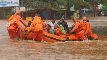 National Disaster Response Force (NDRF) personnel rescue people stranded in floodwaters in Kolhapur, Maharashtra.