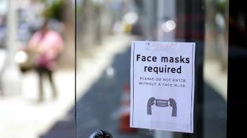 A sign advises shoppers to wear masks outside of a store, in Los Angeles.