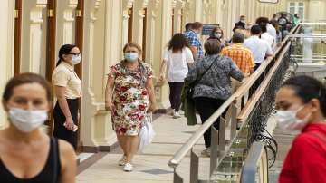 People wait in line to get a coronavirus vaccine at a vaccination center in the GUM, State Department store, in Red Square in Moscow, Russia. 