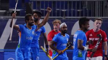 India's Gurjant Singh, left, celebrates after scoring during a men's field hockey match against Brit