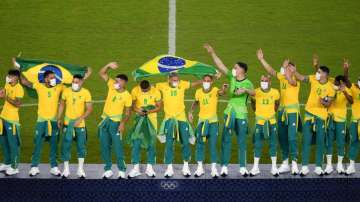 Players of Brazil celebrate at the podium after defeating Spain in the men's soccer final 