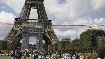 The French Aerial Patrol fly by the Eiffel Tower in Paris, Sunday, Aug. 8