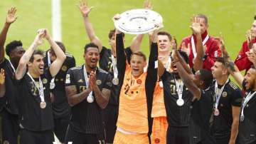 Bayern's goalkeeper Manuel Neuer holds the trophy after winning the Bundesliga title 