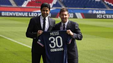 Lionel Messi, right, and PSG president Nasser Al-Al-Khelaifi hold Messi's jersey Wednesday, Aug. 11