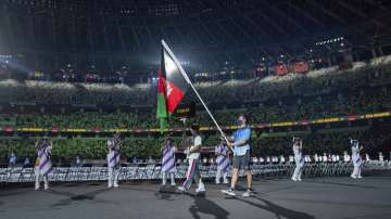 Volunteer carries the Afghanistan national flag during 2020 Tokyo Paralympics opening ceremony