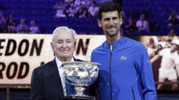 In this Jan. 14, 2019, file photo, Serbia's Novak Djokovic, right, presents a trophy to Rod Laver during the 50th anniversary celebration for the Australian Open and Laver's second Grand Slam at the Australian Open tennis championships in Melbourne