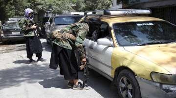 Taliban fighters search a vehicle at a checkpoint on the road in the Wazir Akbar Khan neighborhood in the city of Kabul, Afghanistan.