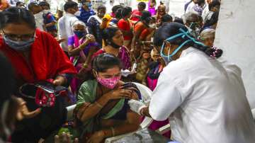 A health worker administers a dose of Covaxin as hundreds line up to receive their second dose of vaccine against the coronavirus at the municipal stadium in Hyderabad.