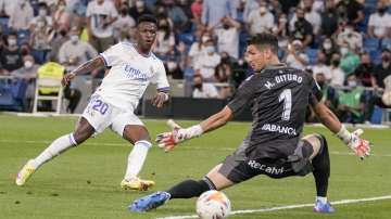 Real Madrid's Vinicius Junior, left, kicks the ball to score during the Spanish La Liga soccer match between Real Madrid and Celta de Vigo at the Bernabeu stadium in Madrid, Spain, Sunday, Sept. 12