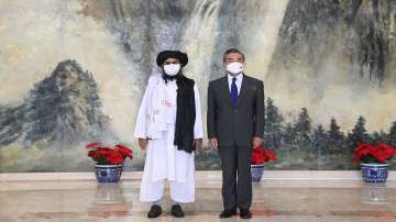 Taliban co-founder Mullah Abdul Ghani Baradar, left, and Chinese Foreign Minister Wang Yi pose for a photo during their meeting in Tianjin, China, Wednesday, July 28, 2021.