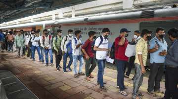 Passengers queue up for Covid-19 testing after arriving at a railway platform on a long-distance train at Dadar railway station in Mumbai.