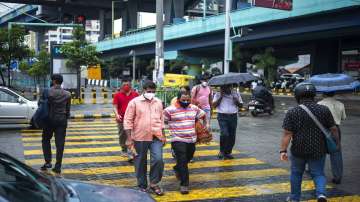 People wearing face masks as a precaution against the coronavirus walk at a pedestrian crossing in Kochi, Kerala.