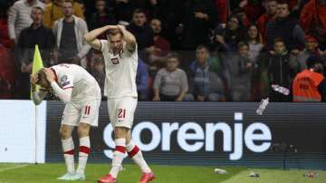 Poland's Karol Swiderski (left) holds his head as fans threw items shortly after scoring the opening