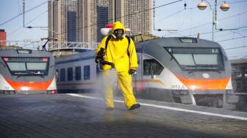 An employee of the Federal State Center for Special Risk Rescue Operations of Russia Emergency Situations disinfects a platform of Savyolovsky railway station in Moscow, Russia, Tuesday, Oct. 26, 2021. The daily number of COVID-19 deaths in Russia hit another high.