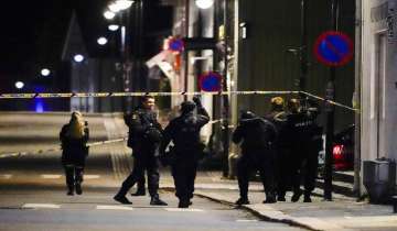 Police stand at the scene after an attack in Kongsberg, Norway.