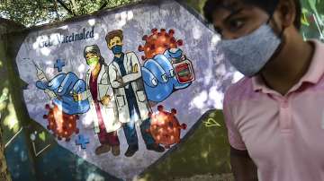Delhi: Man walks past a wall mural depicting COVID-19 frontline workers as India crossed 1 billion Covid-19 vaccine dose milestone on Oct 21.