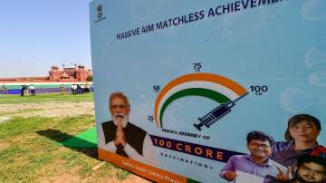 A poster announnces about the 1 billion COVID-19 vaccination milestone crossed by India, at Red Fort premises in New Delhi, Thursday