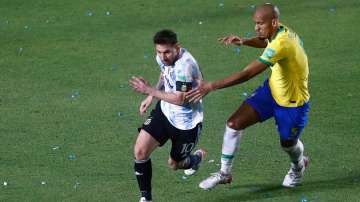 Lionel Messi of Argentina competes for the ball with Fabinho of Brazil during a match between Argent