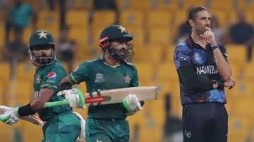 Pakistan's captain Babar Azam and Mohammad Rizwan run between wickets as Namibia's David Wiese watch