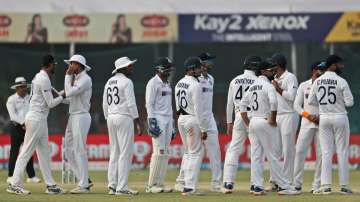 India's players watch the replay on a giant screen as they await the third umpire decision after an 